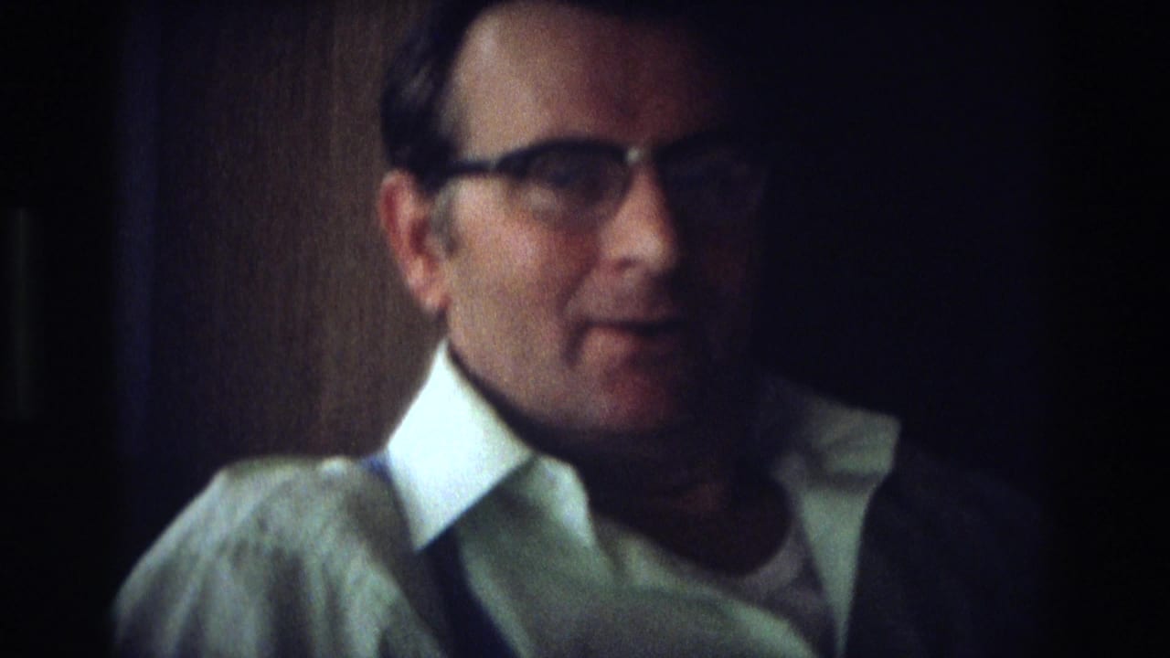 1968 Ocean City home-movie close-up of a middle-aged man in glasses and a white collared shirt indoors.