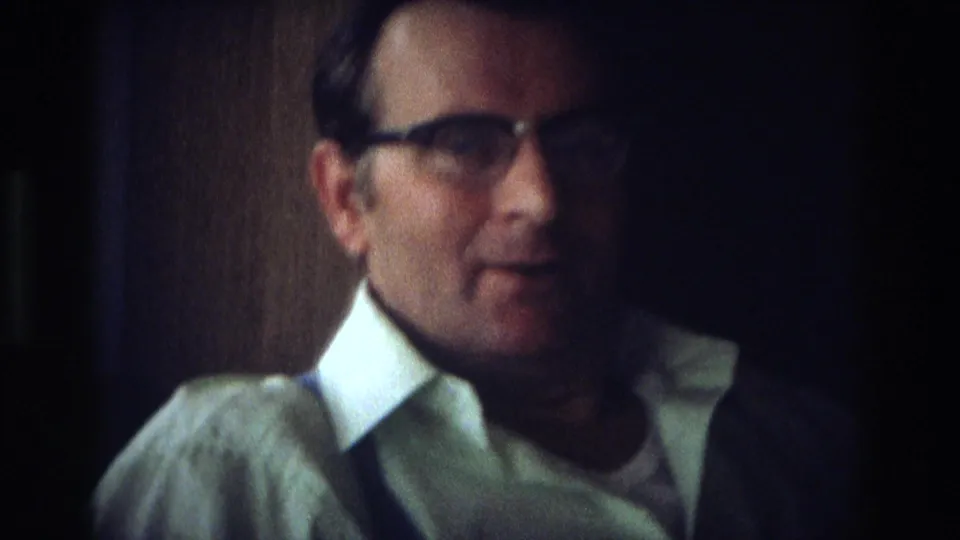 1968 Ocean City home-movie close-up of a middle-aged man in glasses and a white collared shirt indoors.