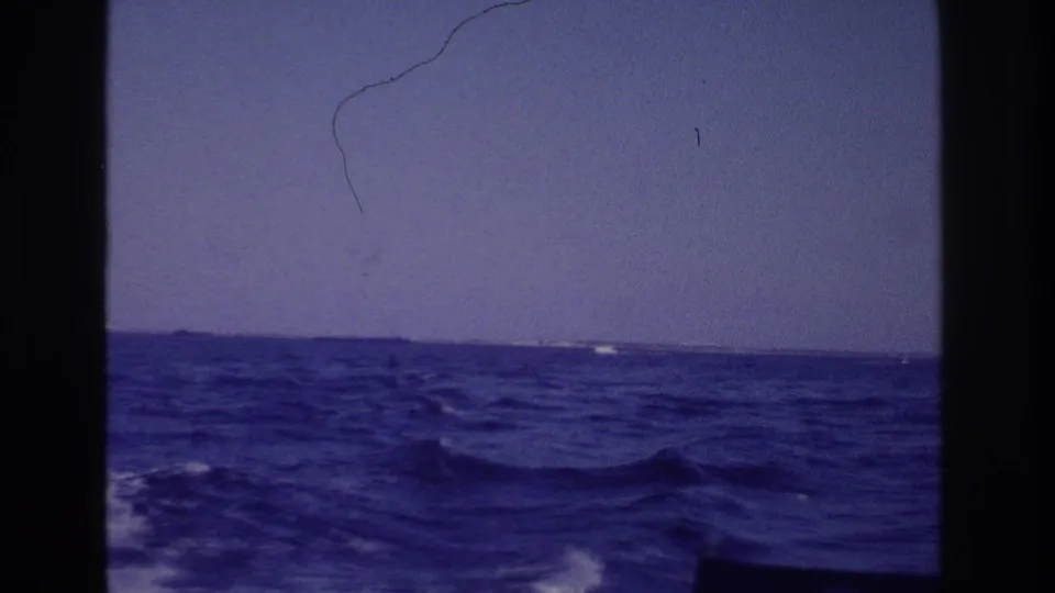 Boat perspective off Ocean City, New Jersey in 1968, with rolling blue water, faint shoreline, and visible film scratches.