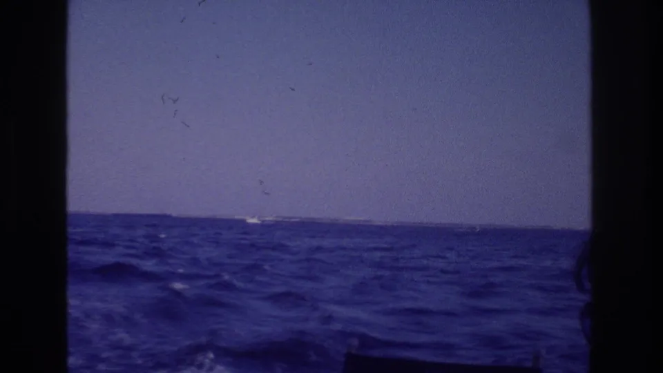 Final 1968 Ocean City boat-view frame, with textured blue sea, distant shoreline, and aged 8mm scan marks.