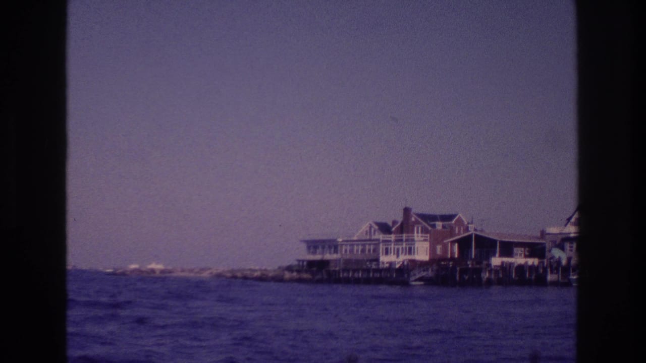 Boat-view frame of Ocean City waterfront buildings, pale sky, and rippled water in purple-blue 8mm color.
