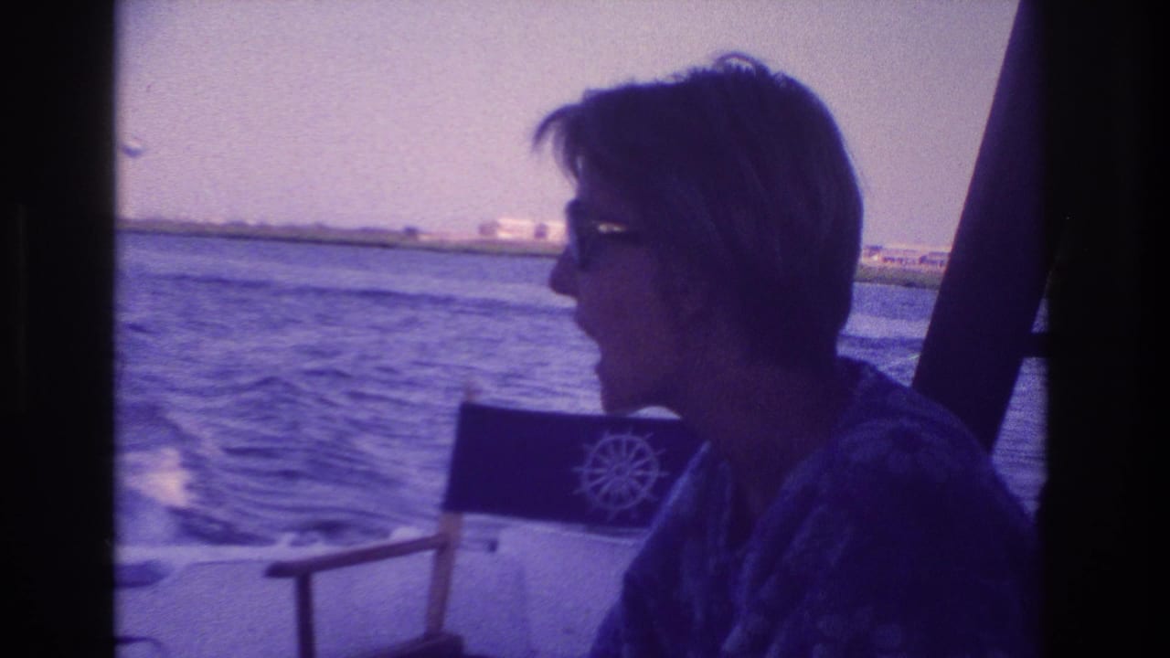 In Ocean City, New Jersey, 1968, a woman in sunglasses sits in profile on a speeding boat as water and shoreline pass behind her.