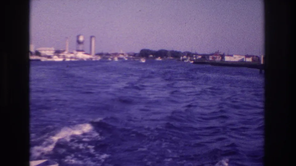 End frame of the 1968 Ocean City boat view, showing wake in the foreground and a hazy shoreline with a prominent water tower.