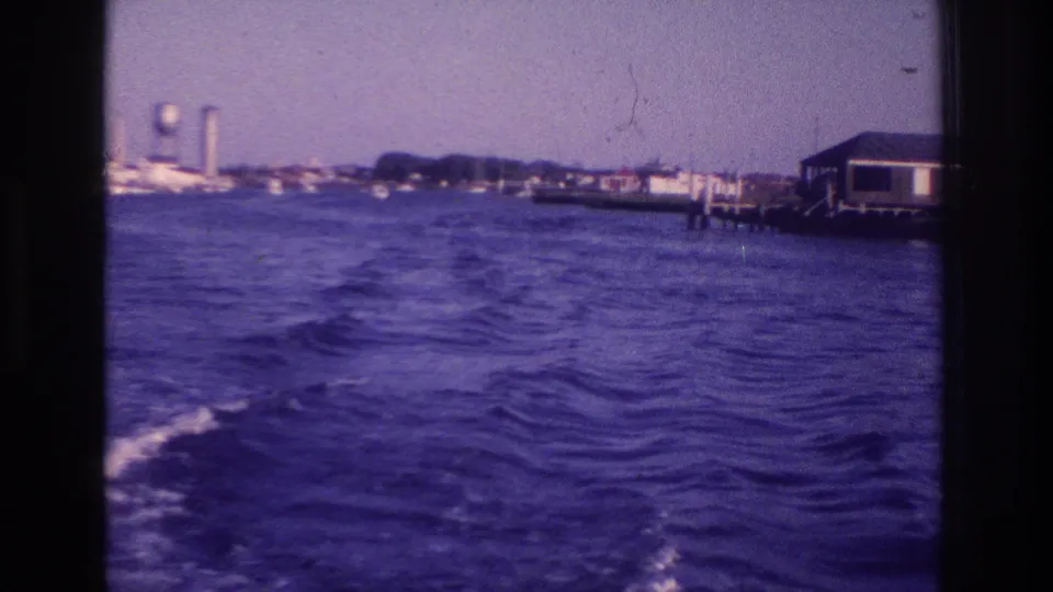 1968 Ocean City, New Jersey waterfront view with choppy water, shoreline docks, a building on pilings, and distant tower structures.