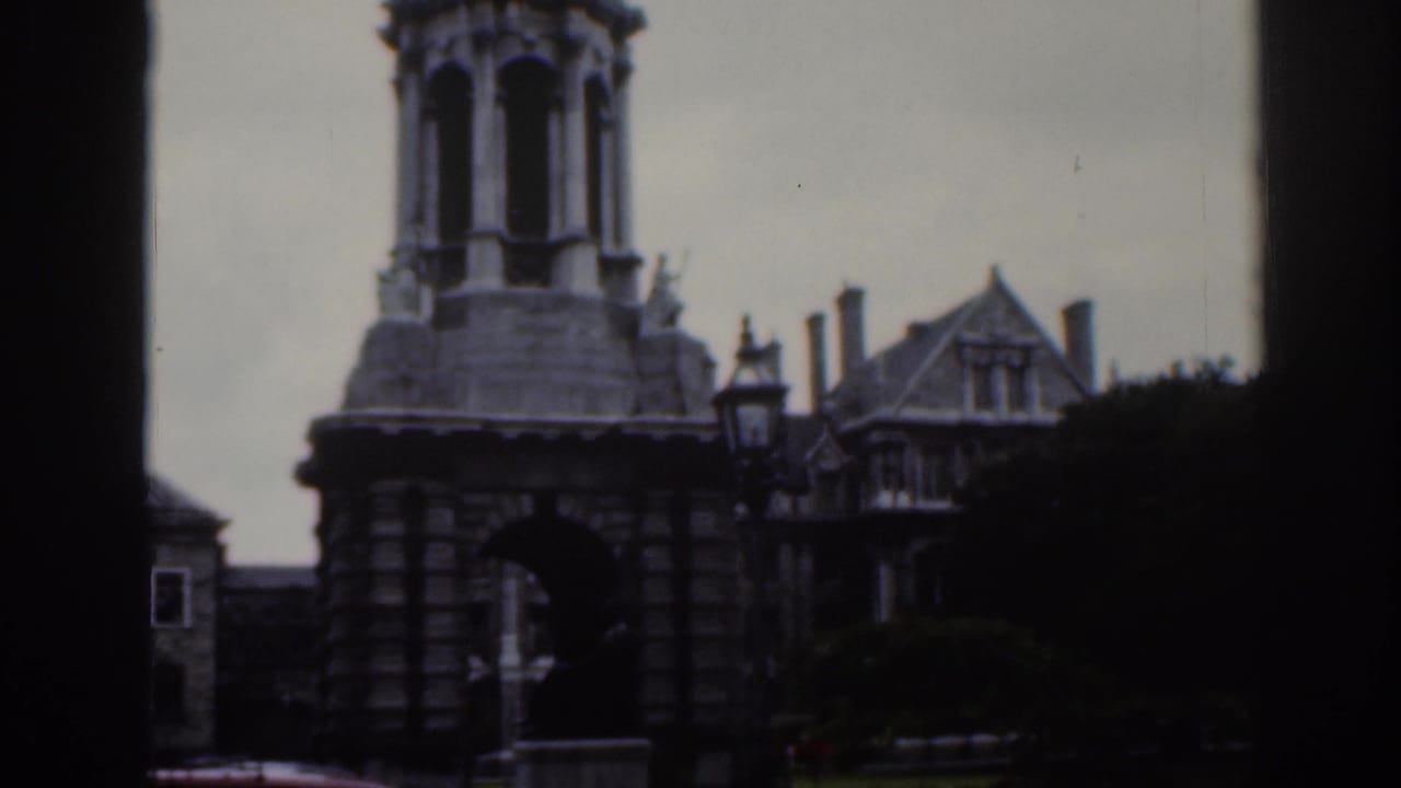 Stone tower, street lamp, and gabled roofline with dark framing at the side.