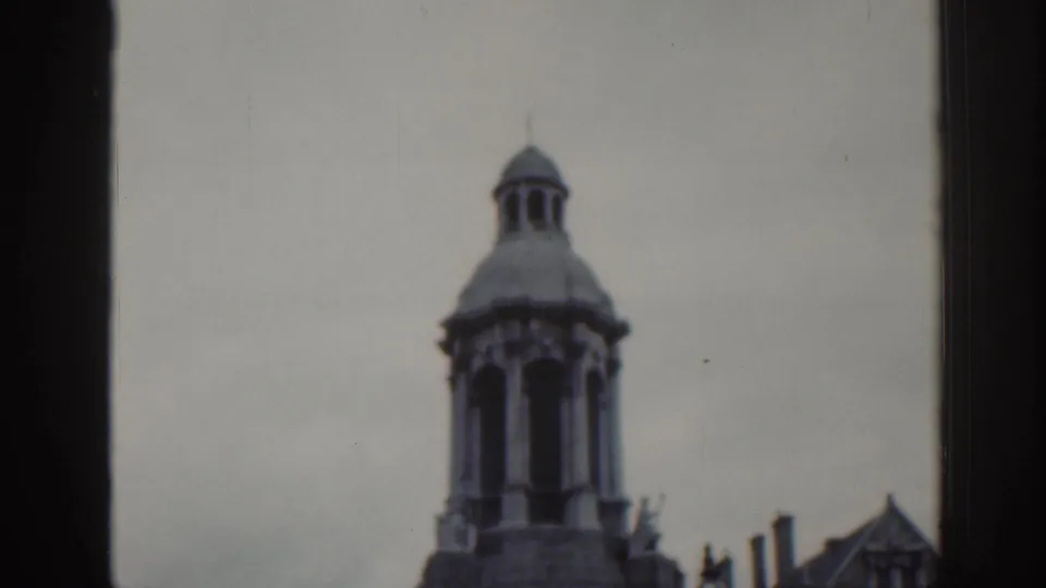 1961 Dublin frame focusing on the upper stone tower and adjoining roofline, with dark frame edges and visible film softness.