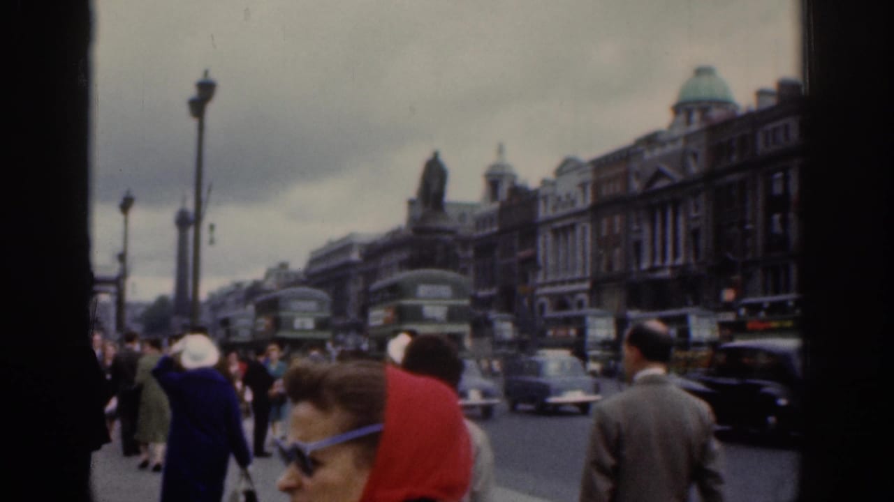 1961 Dublin street scene with pedestrians in period dress, green double-decker buses, vintage cars, shopfronts, and a distant statue.