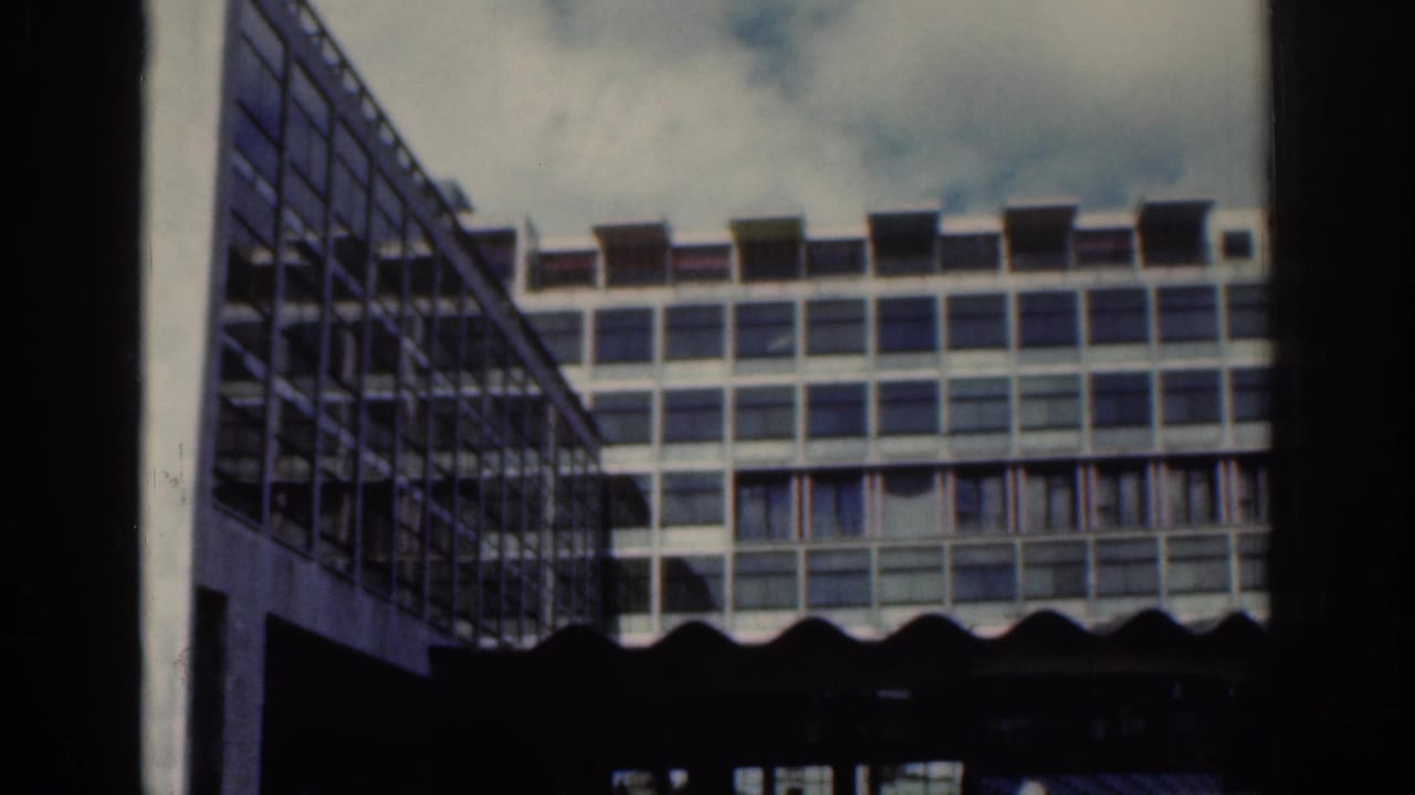 Angled 1961 Dublin view of a modern multi-story building, showing a side facade, window grid, awnings, and cloudy sky.
