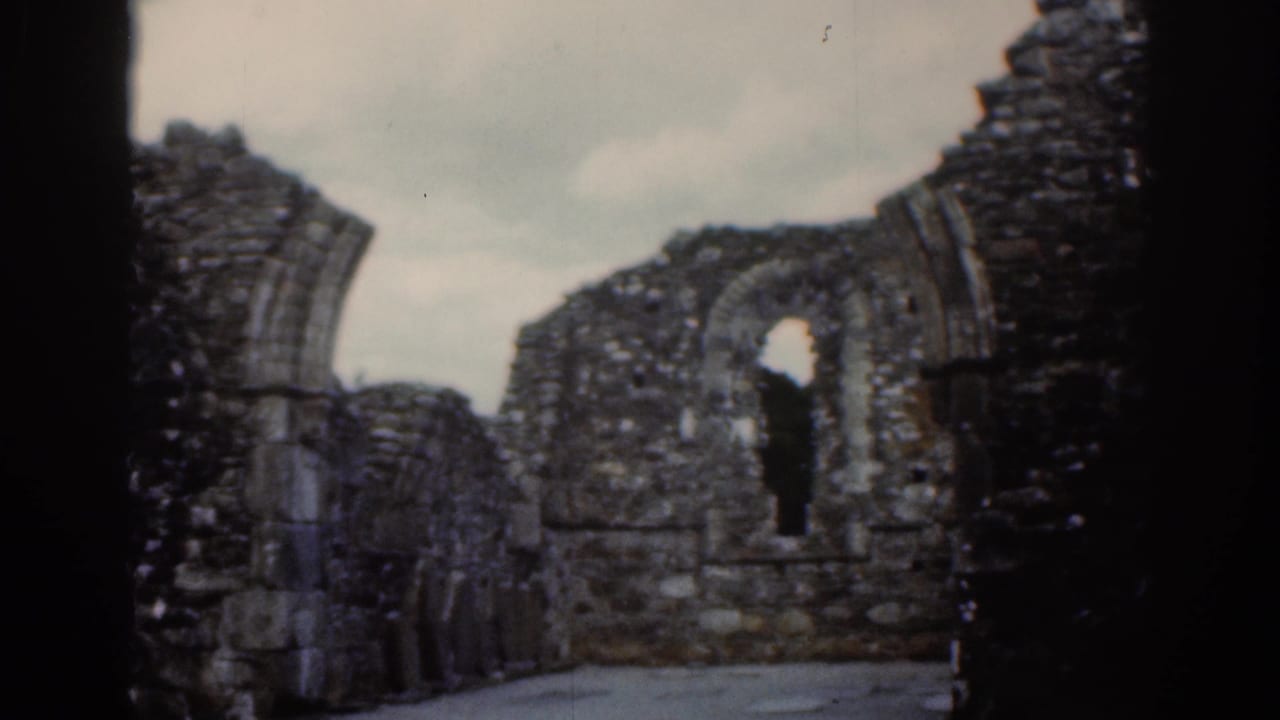 1961 Dublin 8mm frame showing crumbling masonry, an arched opening, and a narrow window within the ruin.