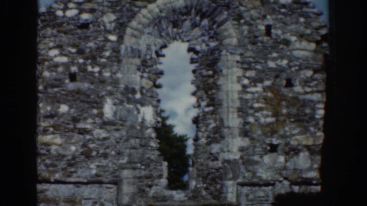 Close view of a weathered arched opening in an Irish stone ruin, filmed on 8mm in 1961.