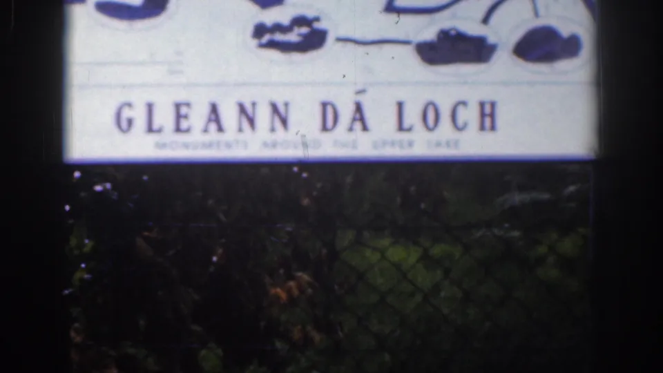 Close 8mm frame of a Gléann Dá Loch sign, with smaller Upper Lake wording partly visible below.