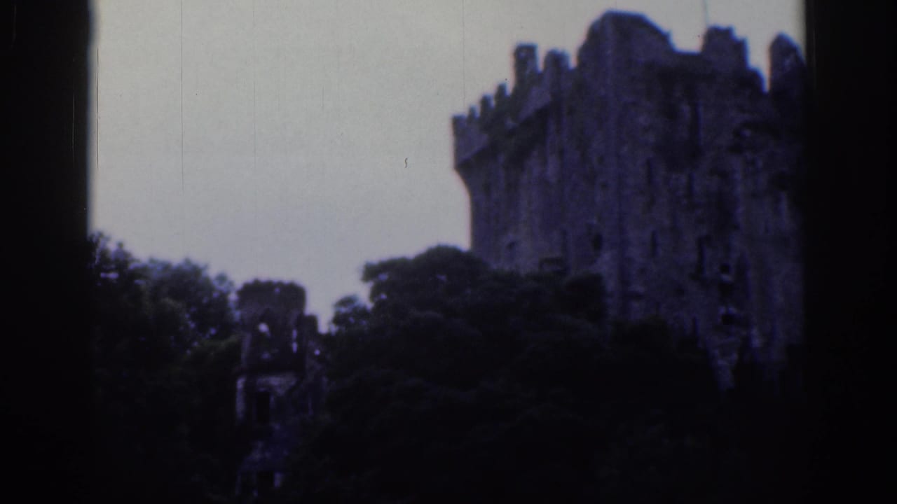 1961 Dublin 8mm frame showing a weathered castle tower near the right edge, partly screened by dark foliage.