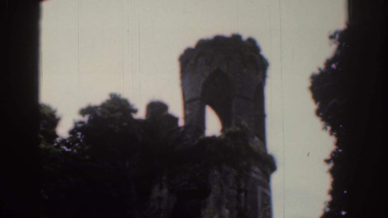 1961 Dublin 8mm frame showing a smaller ruined turret with an arched opening, ivy and surrounding trees.
