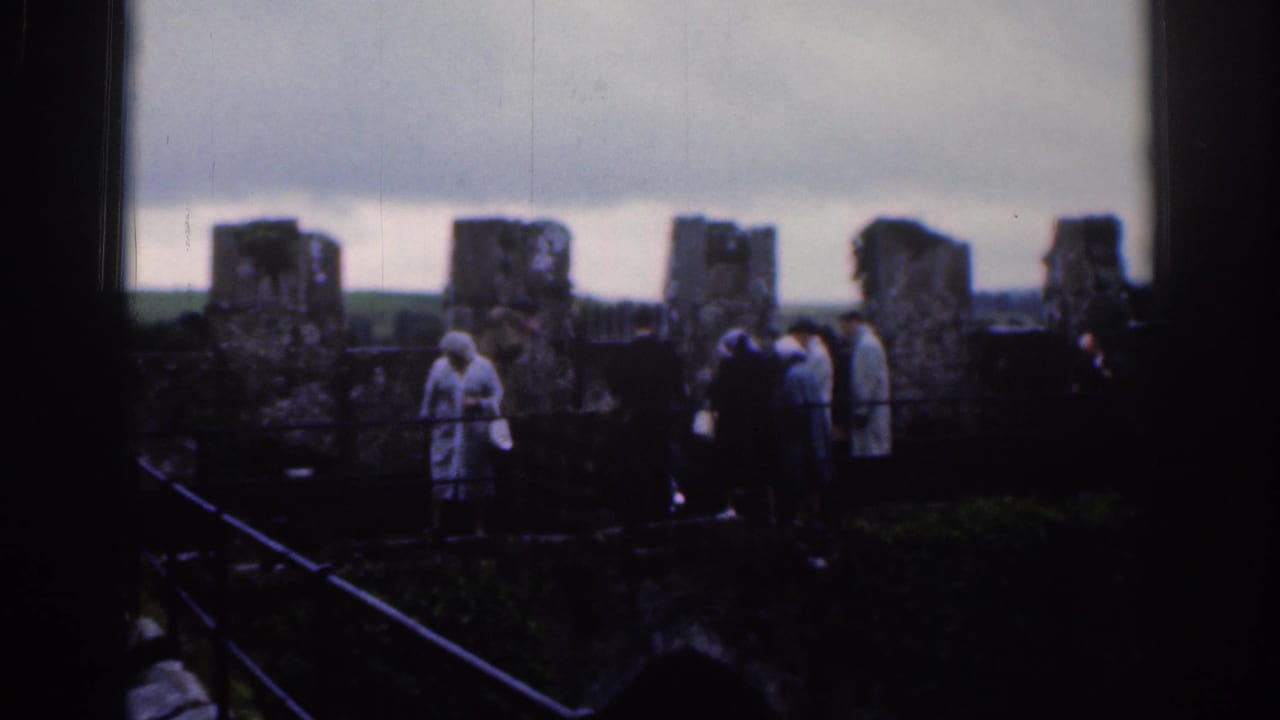 1961 Dublin home-movie frame showing tourists in coats gathered among weathered stone fortress walls.