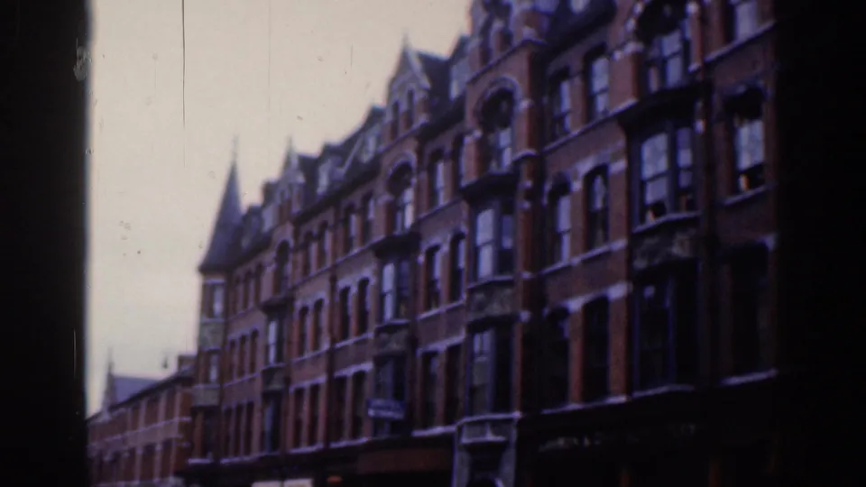 1961 Dublin street view showing red-brick Victorian-style buildings, tall windows, and a pointed turret.