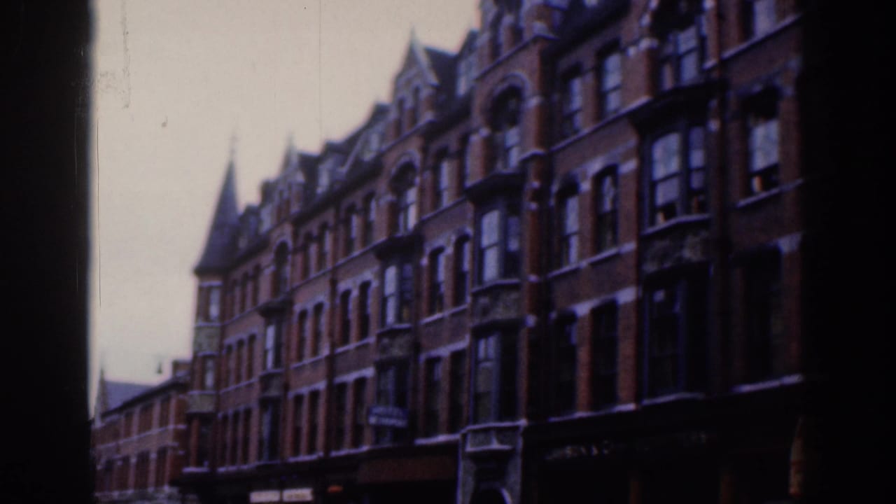 Red-brick townhouses with bay windows seen through dark frame edges.