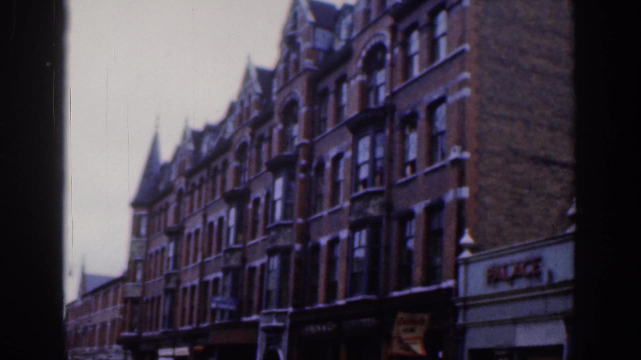 1961 Dublin view of tall red brick facades, bay windows, ground-floor shops, and visible PALACE signage on the right.