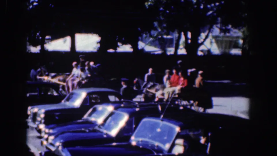 1961 Dublin frame showing the horse-drawn buggy amid parked automobiles and pedestrians in dark shade and bright street light.