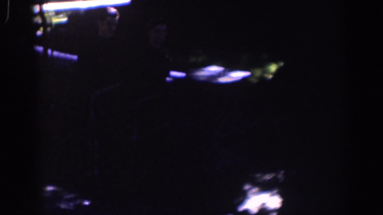 Very dark frame with a faint cart or vehicle form near the upper right.