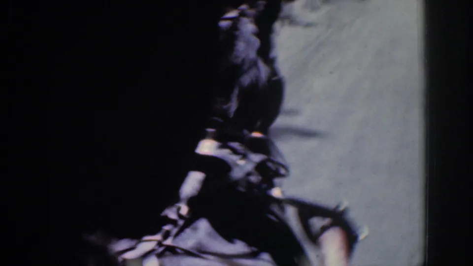 Close, dark 8mm frame of a horse head and harness seen from a moving point of view in 1960s Ireland footage.