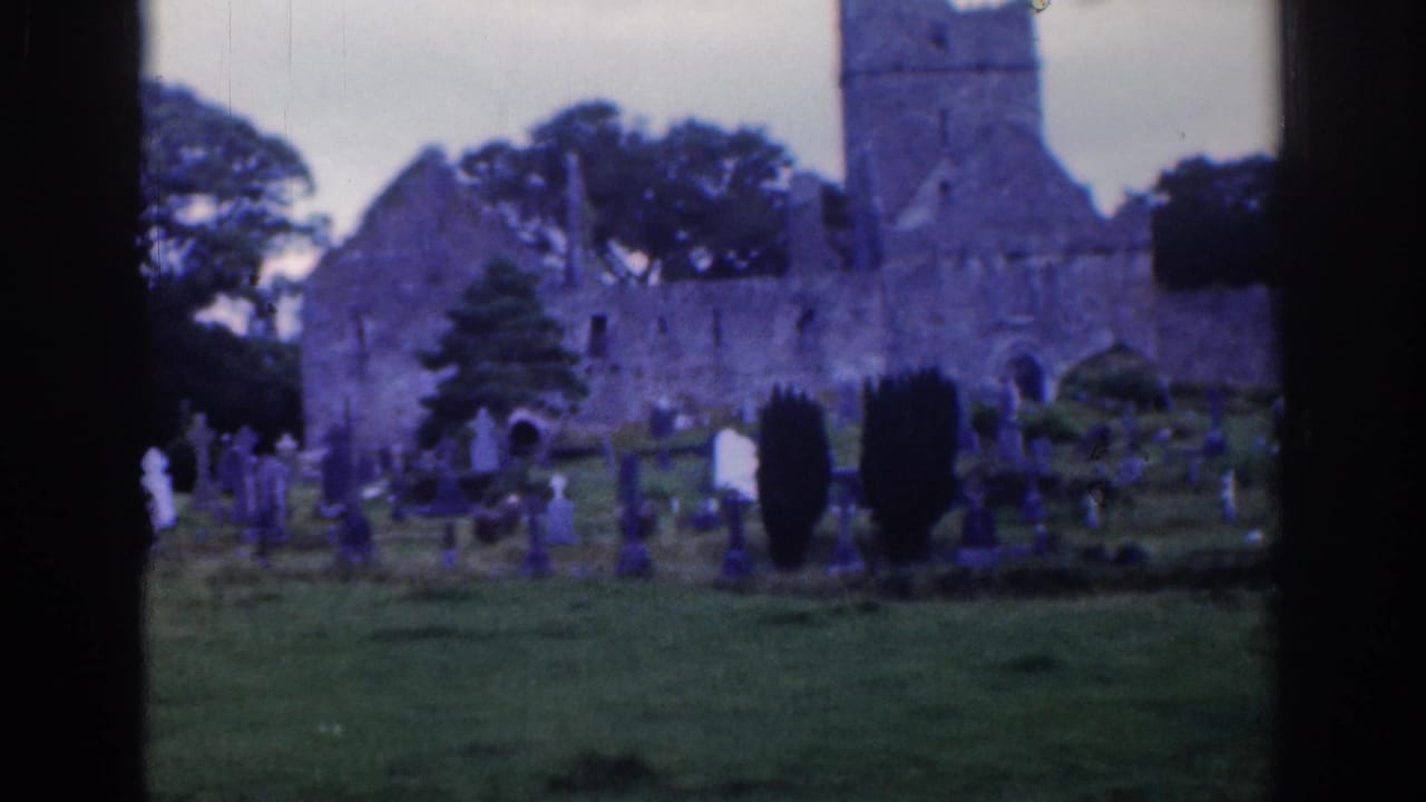 Cemetery with gravestones before a stone church ruin and tower.