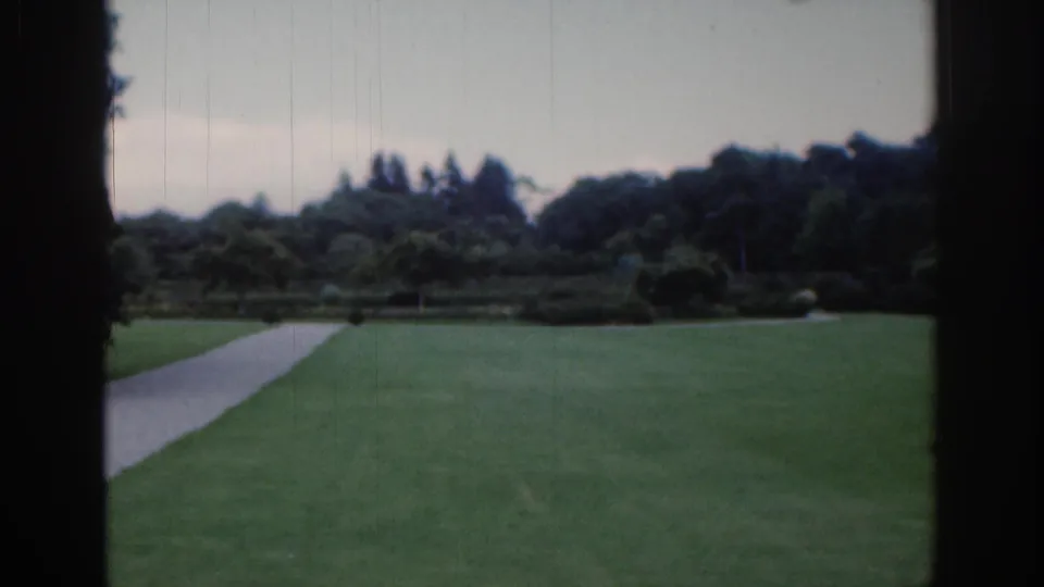 A second empty park view shows the lawn and path continuing through shrubs and trees in the supported 1961 Dublin setting.