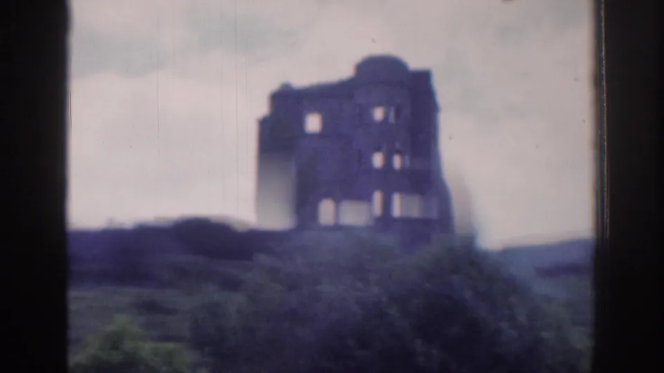 The 1961 Dublin-area clip shows a ruined stone structure on a hill, framed with soft focus and visible 8mm scan texture.