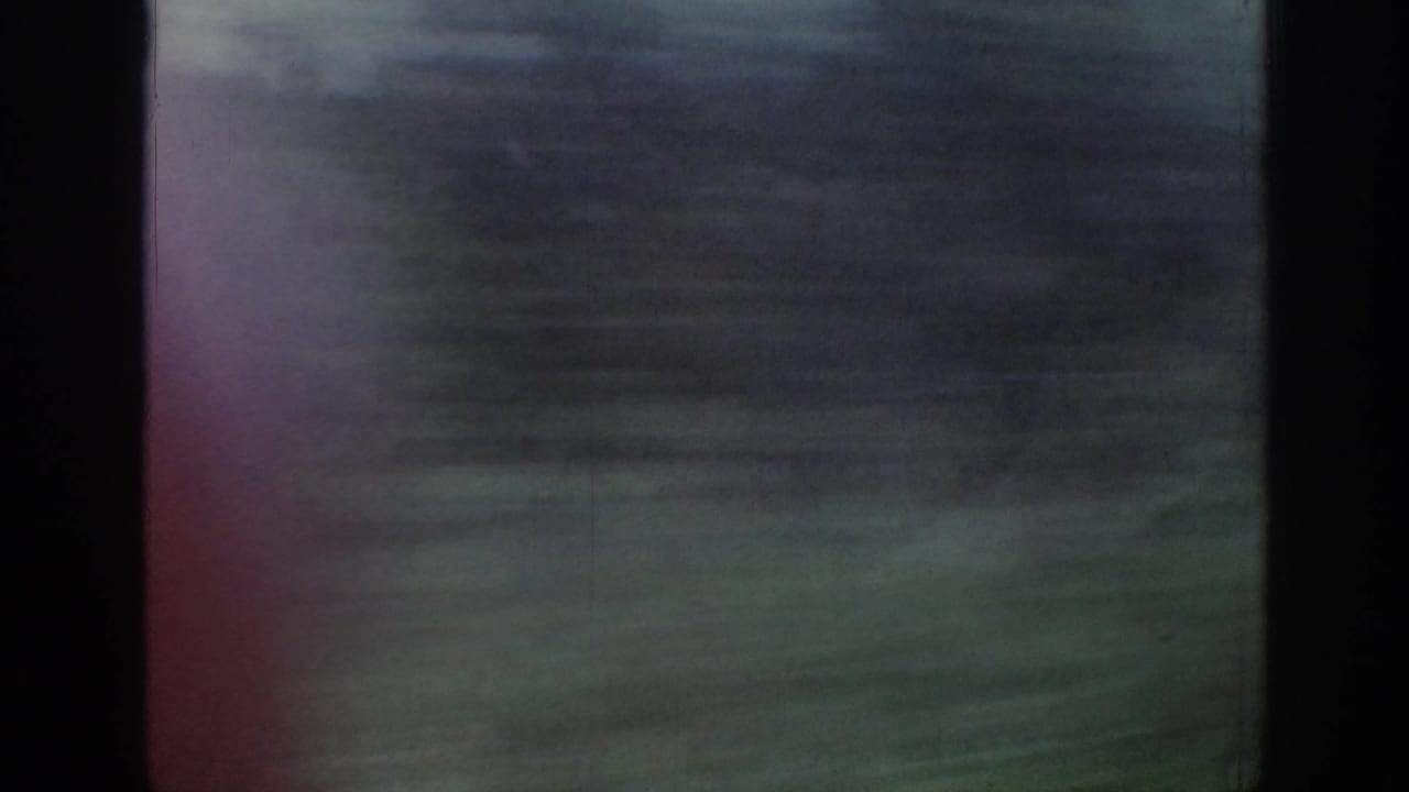 Train-window view in Ireland, 1961, with green field, distant horizon, and strong motion blur from travel.