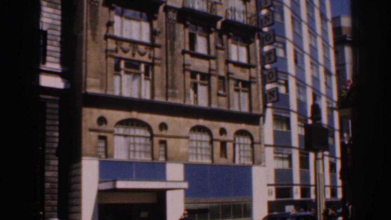 Street-side view of a building with arched windows and a blue storefront band.