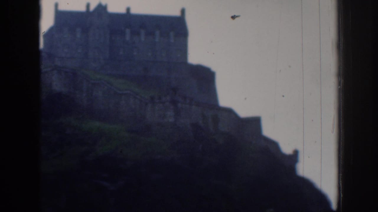 Soft 8mm view of the metadata-identified Edinburgh Castle on a rocky hill, with dark framing at both sides and visible film wear.