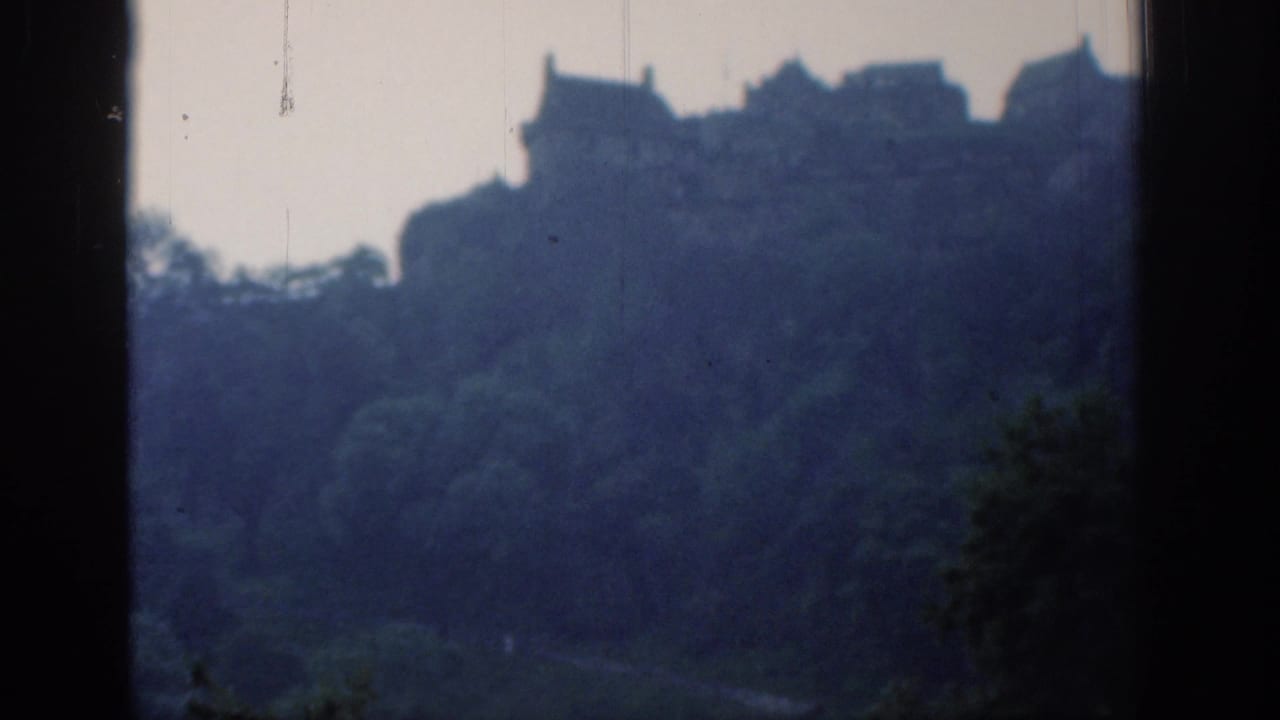 Distant 1961 London hillside view with soft building outlines, trees, dark borders, and visible film wear.