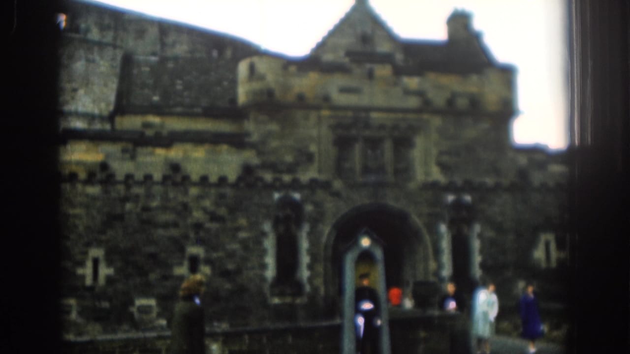 1961 London 8mm frame shows tourists near a guarded arched entrance, with the sentry box centered below the stone facade.