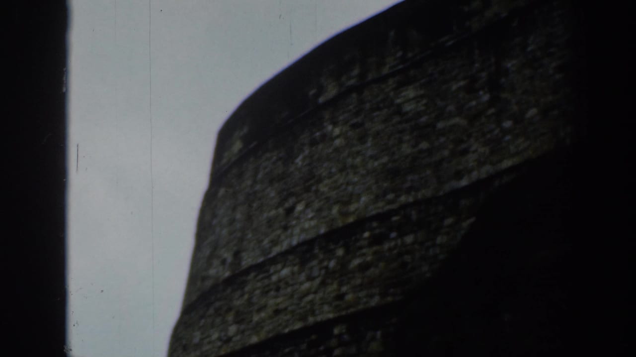 Close view of rough stone masonry with dark framing at the side.