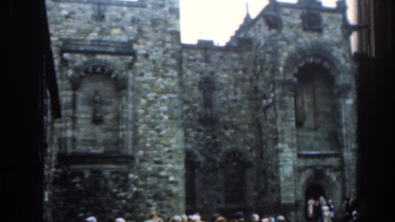 Stone church wall with arched window details and people along the lower edge.