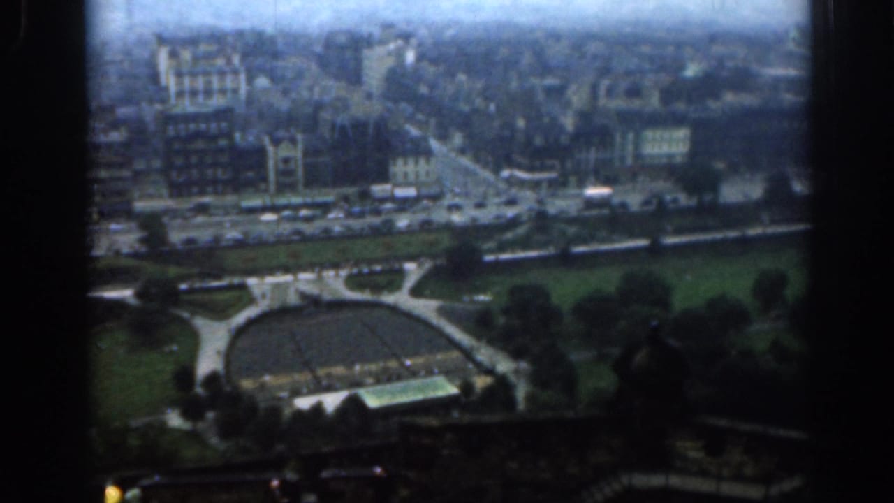 Elevated view over London streets, buildings, park lawns, and a circular paved feature.