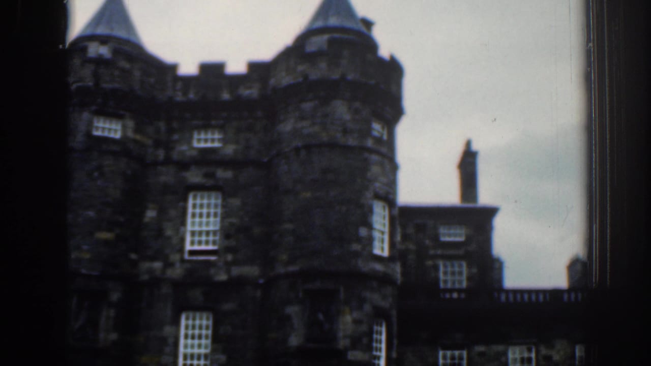 1961 London home-movie frame with a closer handheld view of round turrets, sash windows, and adjoining stonework.