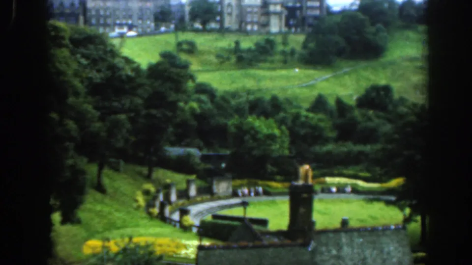 A wider 1961 Scotland view shows formal hedges, a curving path, lawns, tiny visitors and castle-like buildings beyond the park.