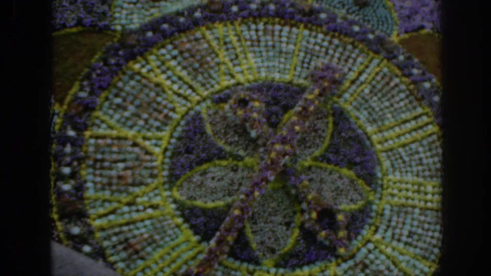 1961 Scotland 8mm frame showing a circular floral arrangement with radiating rows and a central decorative motif.