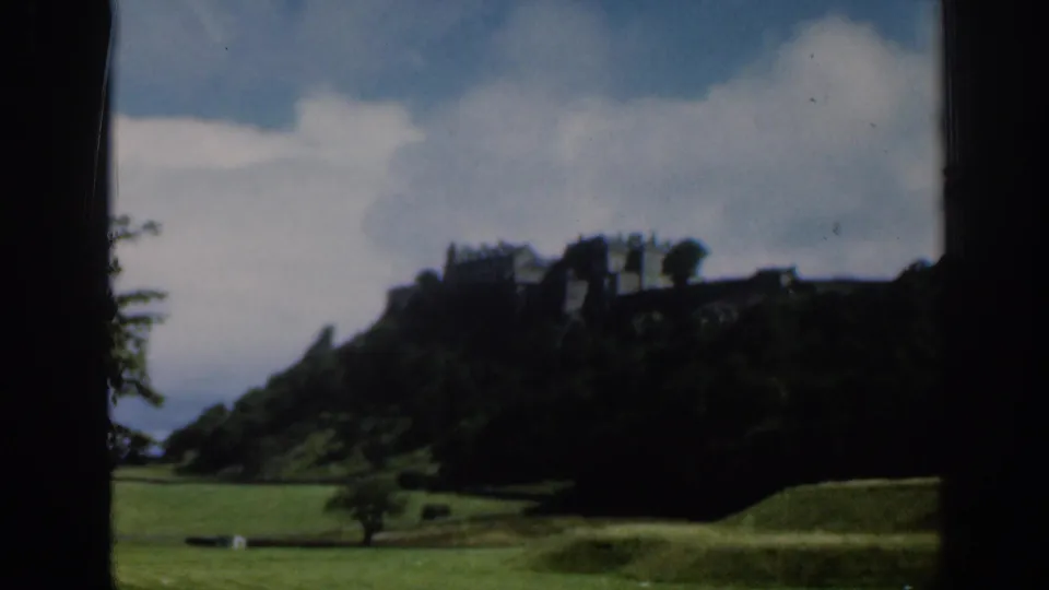 Final 1961 Scotland frame holds on Edinburgh Castle across grass and trees, with soft color and heavy 8mm border shadow.