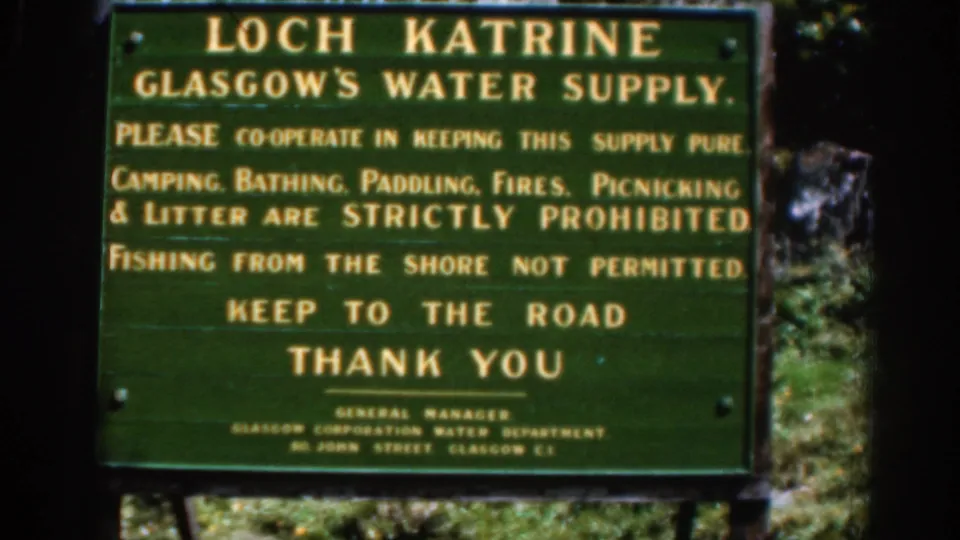 Final close frame of the Loch Katrine Glasgow water-supply notice, showing yellow rules text on a green sign in a wooded setting.
