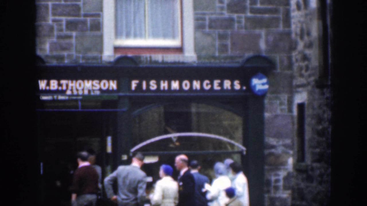 A small crowd stands outside the W.B. Thomson fishmongers storefront.