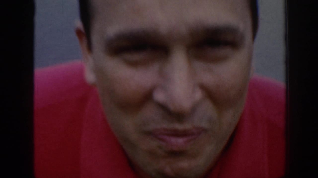 In this 1961 Scotland home-movie frame, an adult man in a red shirt fills the shot while looking toward the camera.