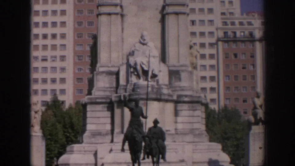 Closer 1966 Madrid frame showing equestrian figures at the monument base, with Edificio España and nearby buildings in the background.