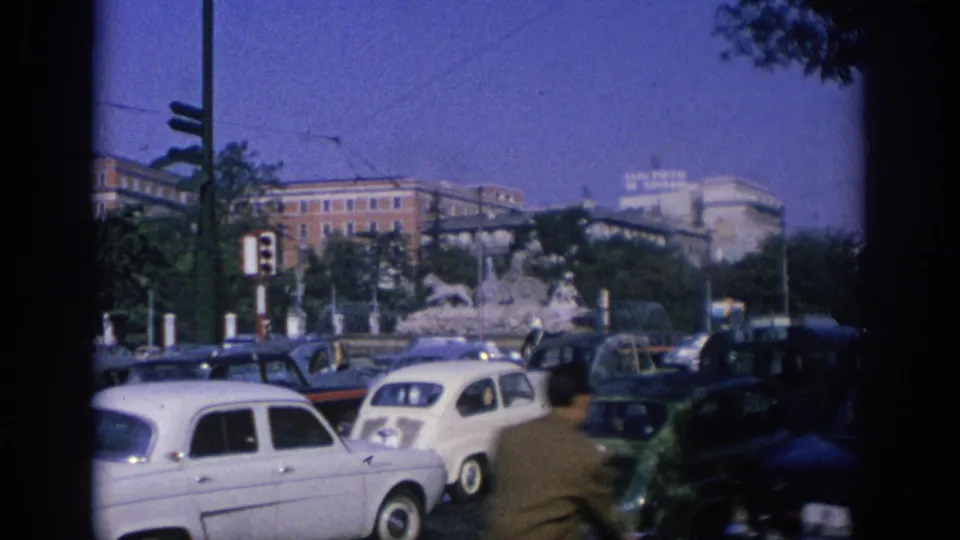 The final Spain 1966 frame shows a white compact car, other vehicles, a fountain, traffic lights, and city buildings in soft 8mm color.