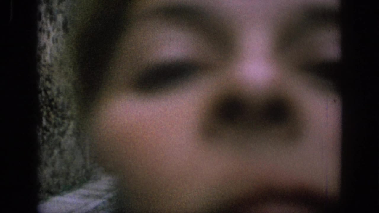 Blurred close face at the right edge with the stone lane visible behind.