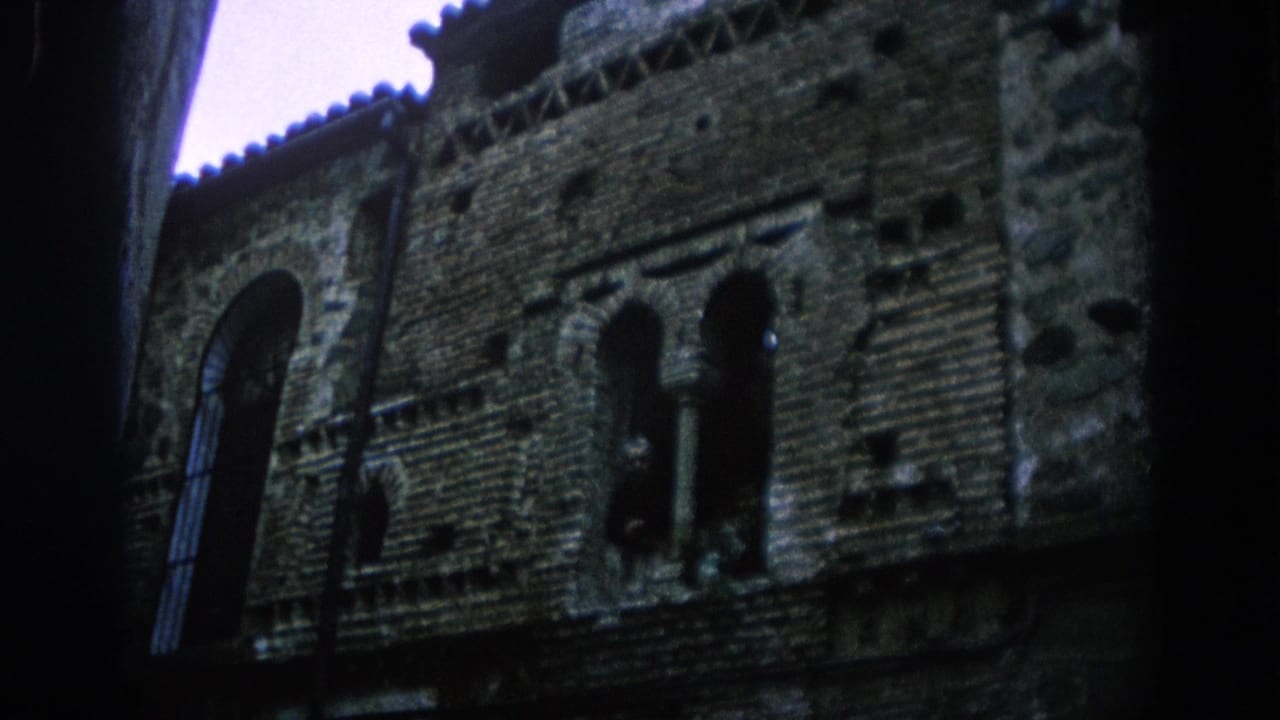Historic masonry wall with arched openings, seen from below and partly framed by shadow.