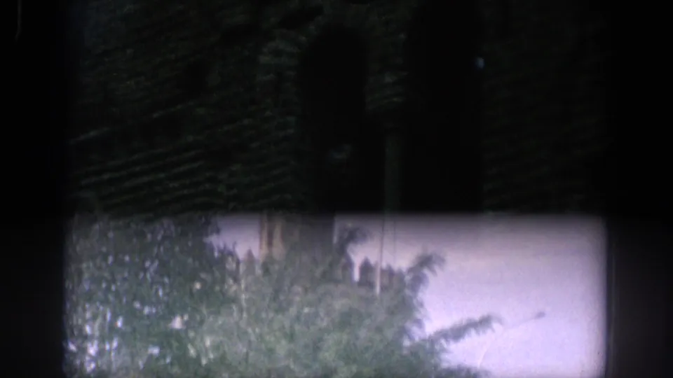 1966 Spain 8mm frame shifting into daylight, with trees and part of a pale tower visible near the lower edge.