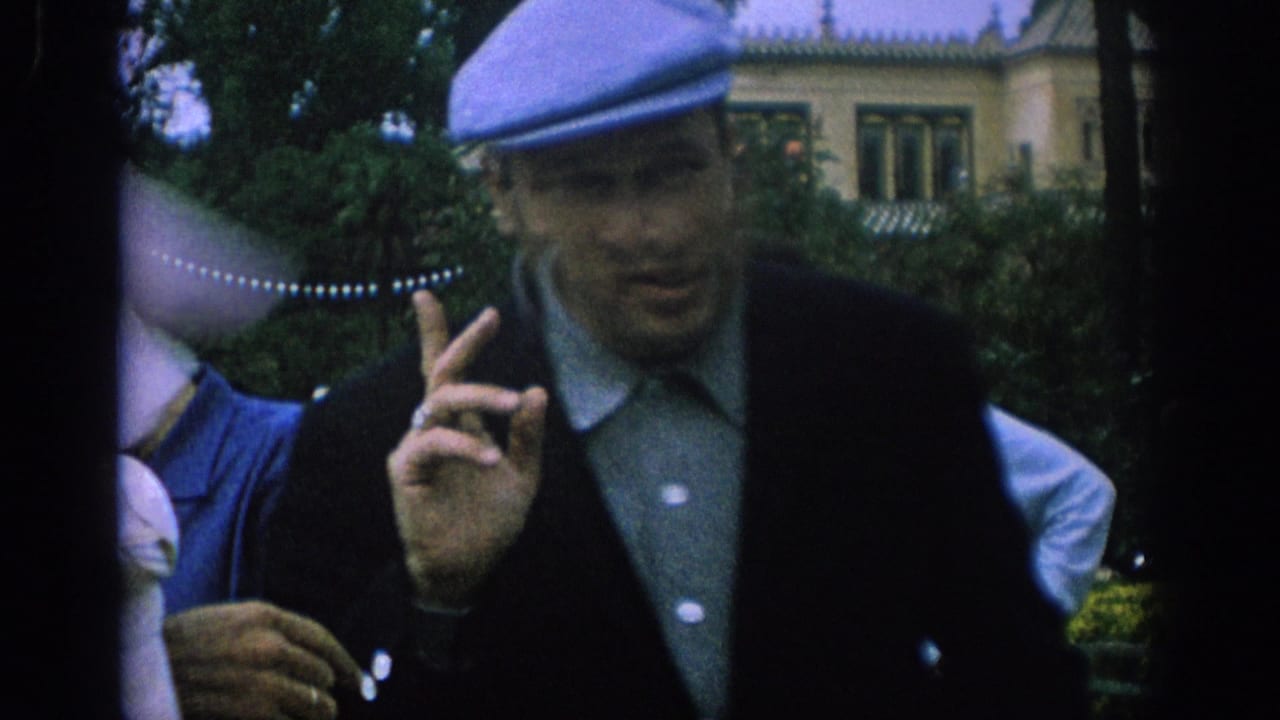 Man in a blue cap gestures toward the camera while a dove rests nearby.