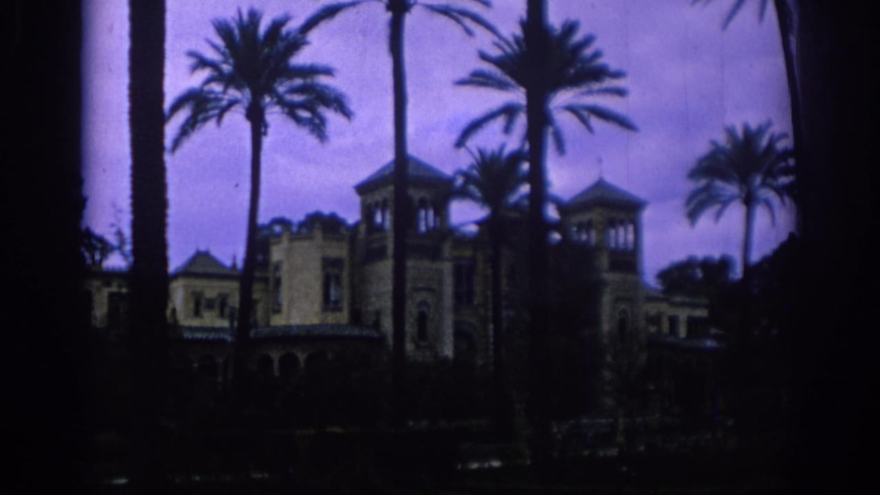 Palm-lined Spanish resort or garden building appears in a soft 8mm establishing shot from 1966.