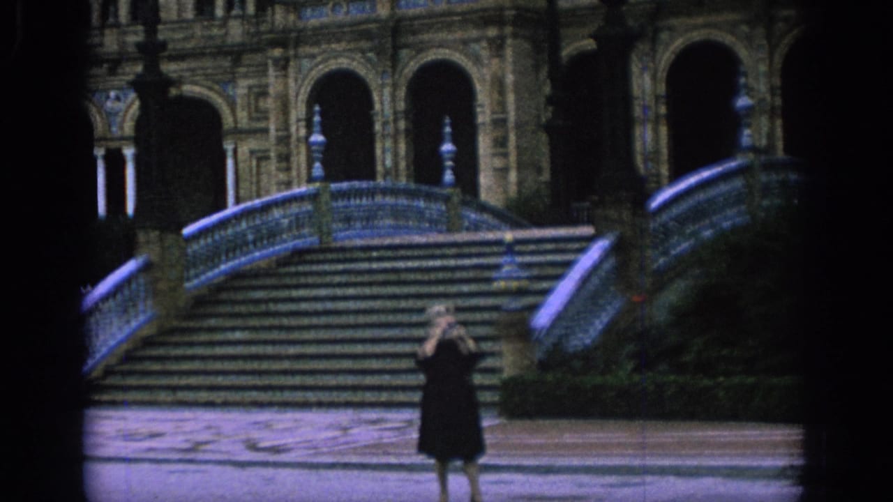 Tourist raises a camera in front of the staircase and curved tiled railing.